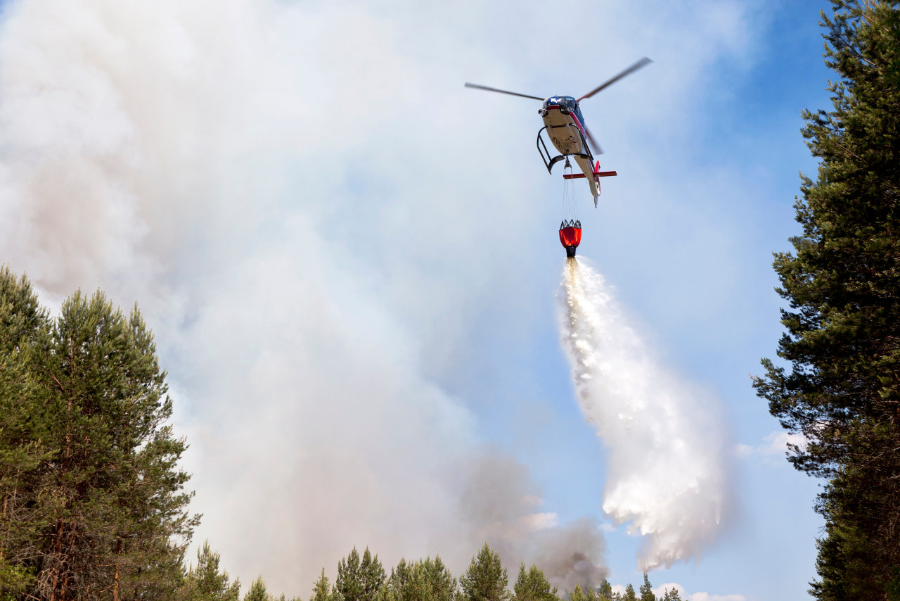 Helikopter släcker skogsbrand
